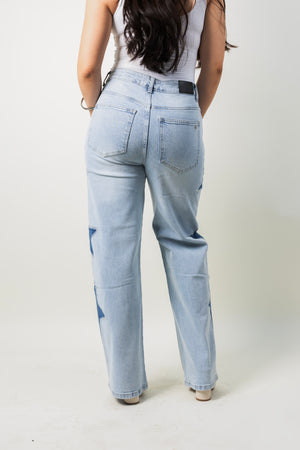 Barrel jeans azul claro con estrellas decorativas vista trasera.
