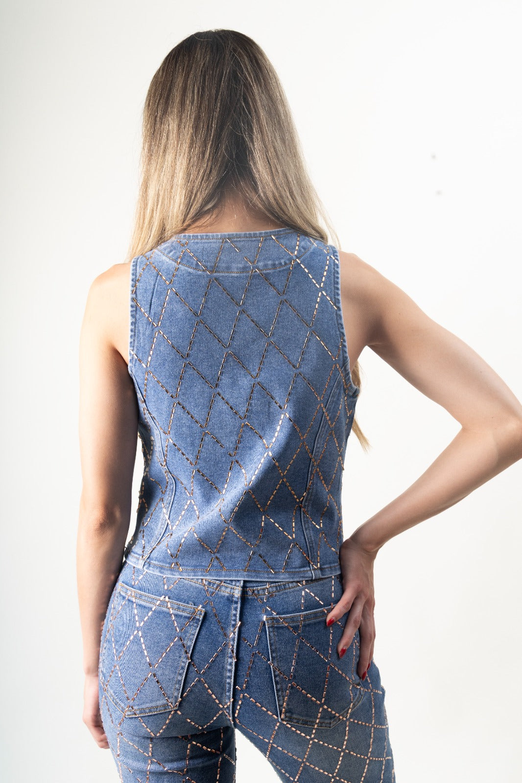 Chaleco de mezclilla blue con diseño de rombos y pedrería rosegold, vista trasera.