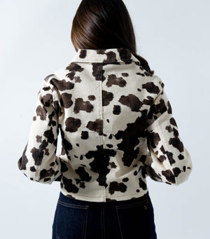 Vista trasera de chamarra de mezclilla estampada cow print para mujer