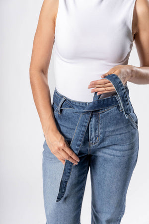 Detalle frontal de pantalon acampanado blue con cinturón ajustable de denim