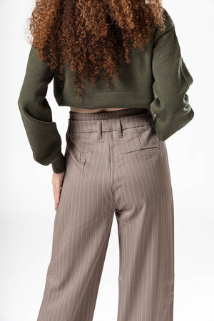 Vista trasera cercana de pantalon de vestir taupe con bolsas posteriores