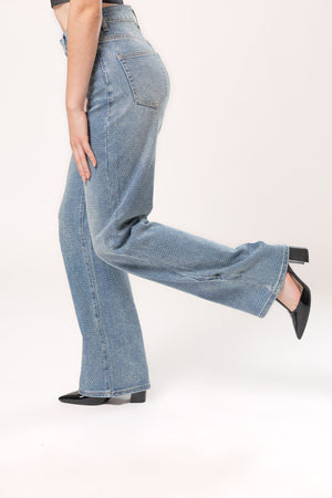 Detalle lateral de pantalón recto con brillos en mezclilla azul