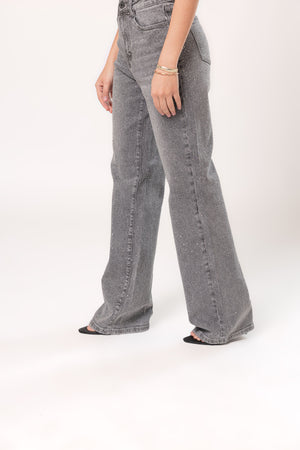 Detalle lateral de pantalón recto gris con brillos y textura brillante