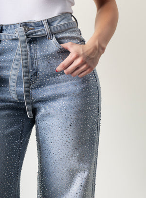 Detalle de brillos decorativos en pantalon wide leg de mezclilla azul.