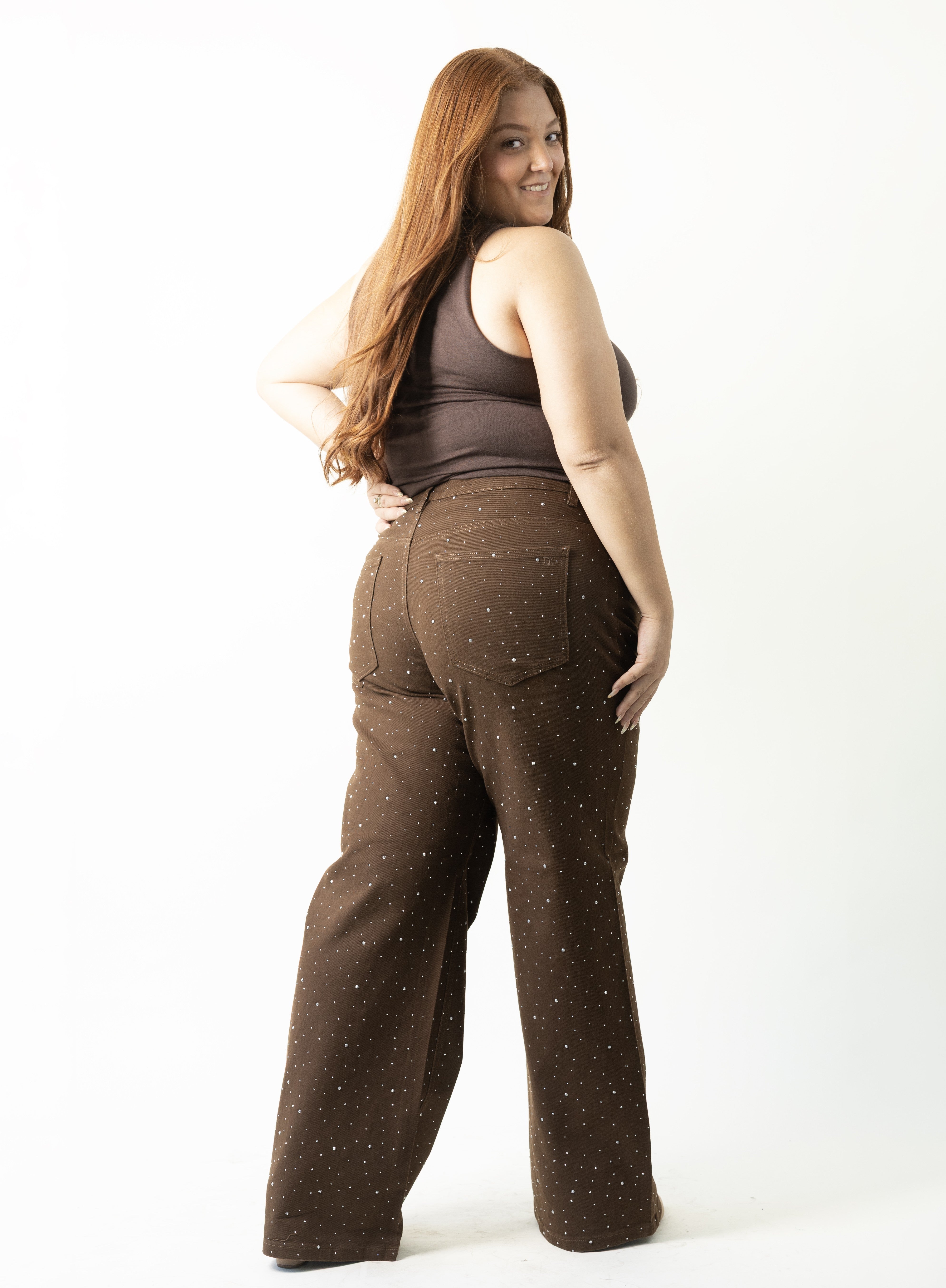 Pantalon wide leg curvy color café con aplicación de piedras decorativas, vista posterior lateral.