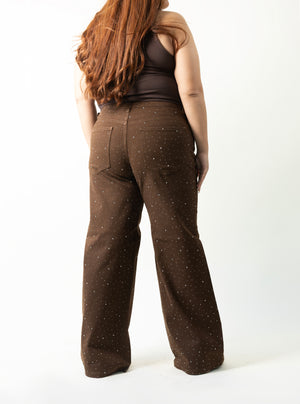 Pantalon wide leg curvy café con bolsillos traseros y detalles de piedras brillantes, vista posterior.