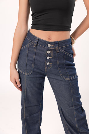 Detalle frontal de pantalon wide leg azul oscuro con botonadura metálica y costuras visibles