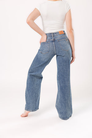 Vista trasera de pantalon wide leg azul para mujer con silueta amplia