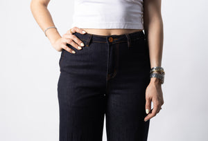 Detalle frontal de pantalon wide leg con botón, pretina y bolsillos delanteros