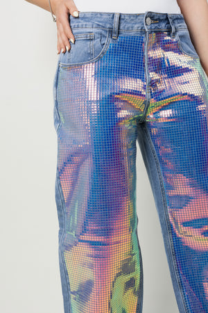 Detalle frontal de pantalon wide leg con paneles holográficos multicolor.