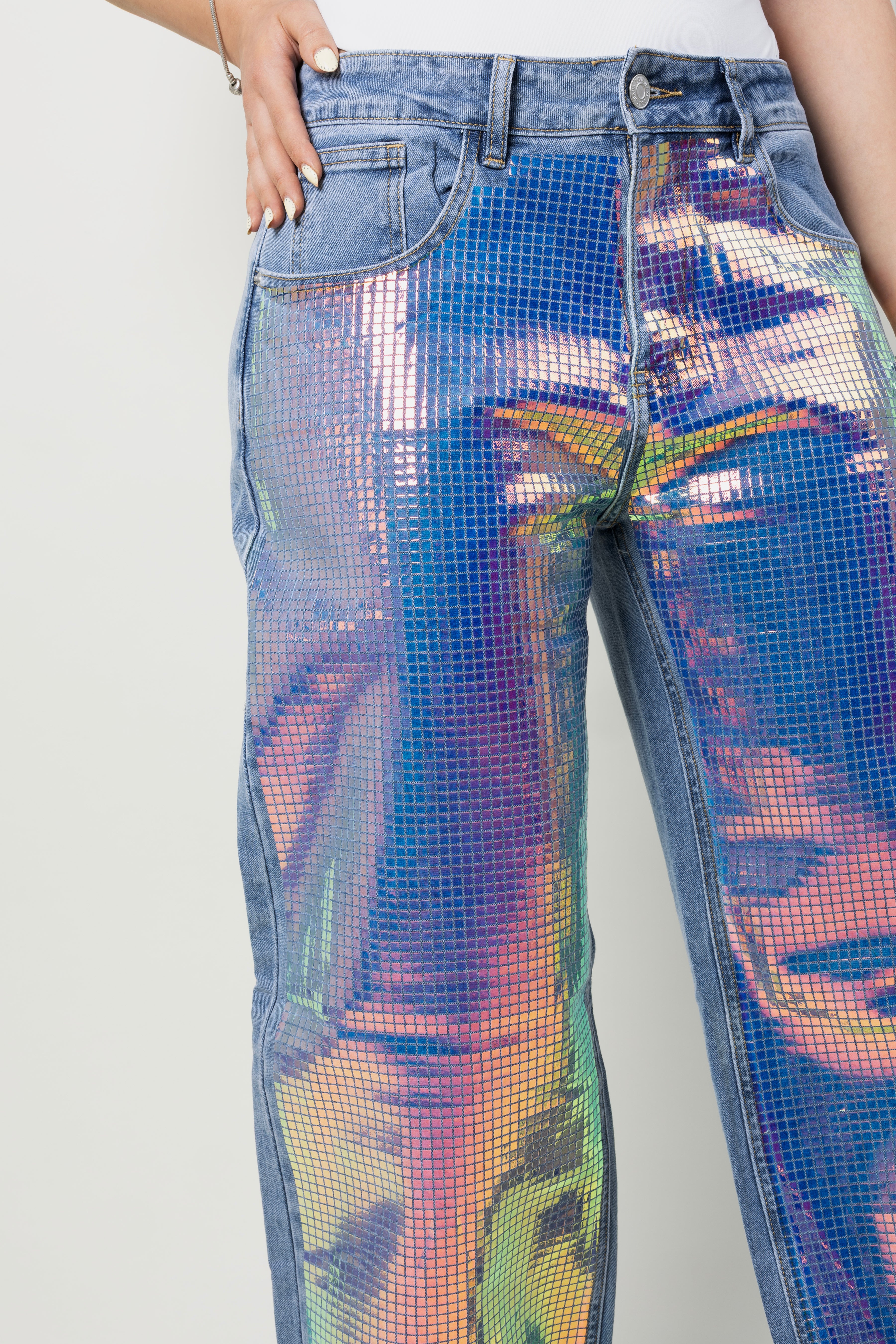 Detalle frontal de pantalon wide leg con paneles holográficos multicolor.