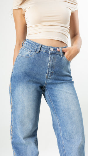 Detalle de pantalon wide leg azul con bordado camel
