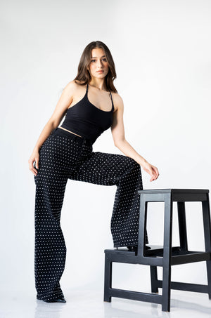 Modelo usando pantalon wide leg negro con brillos blancos de tiro alto Doux Denim.
