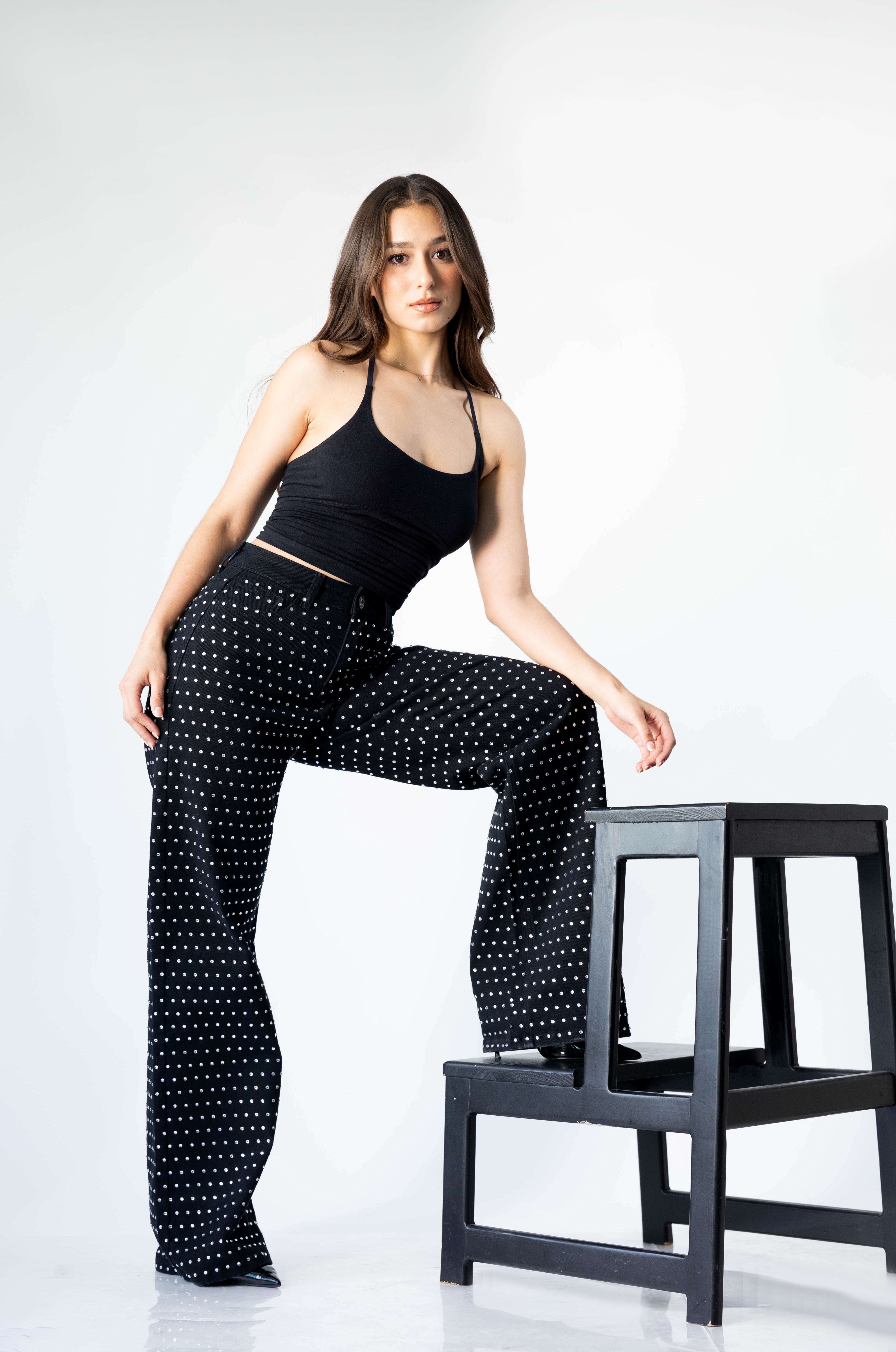 Modelo usando pantalon wide leg negro con brillos blancos de tiro alto Doux Denim.
