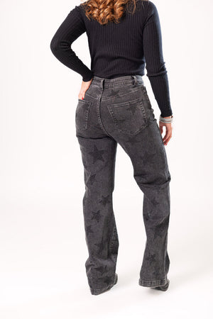 Vista trasera de pantalon wide leg negro con aplicaciones de estrellas brillantes