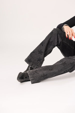 Detalle de pantalon wide leg negro con estrellas brillantes y pierna amplia