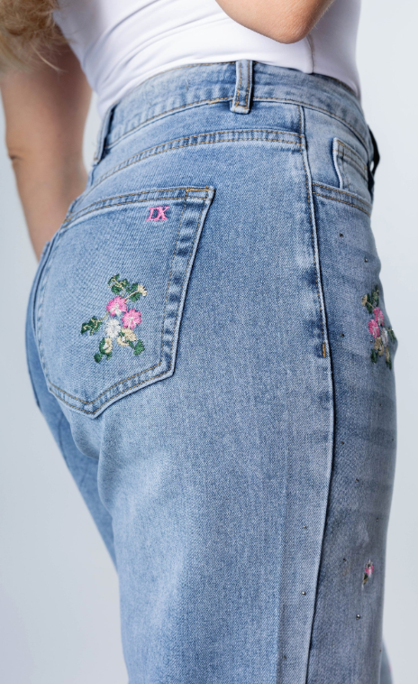 new collection women’s light denim jeans with floral embroidery detail back pocket close-up