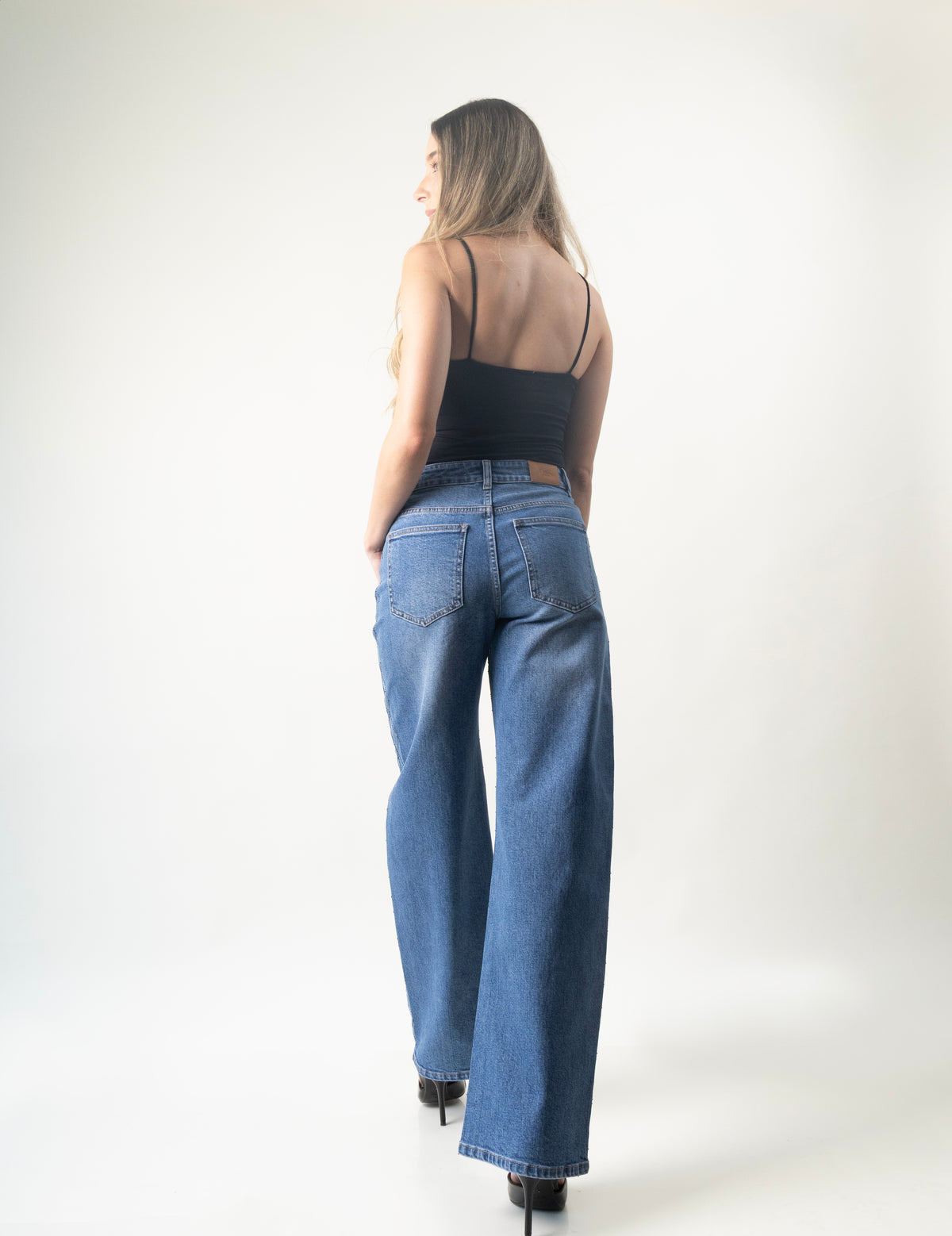 Vista trasera del barrel jeans azul medio DXD0585 usado por modelo.