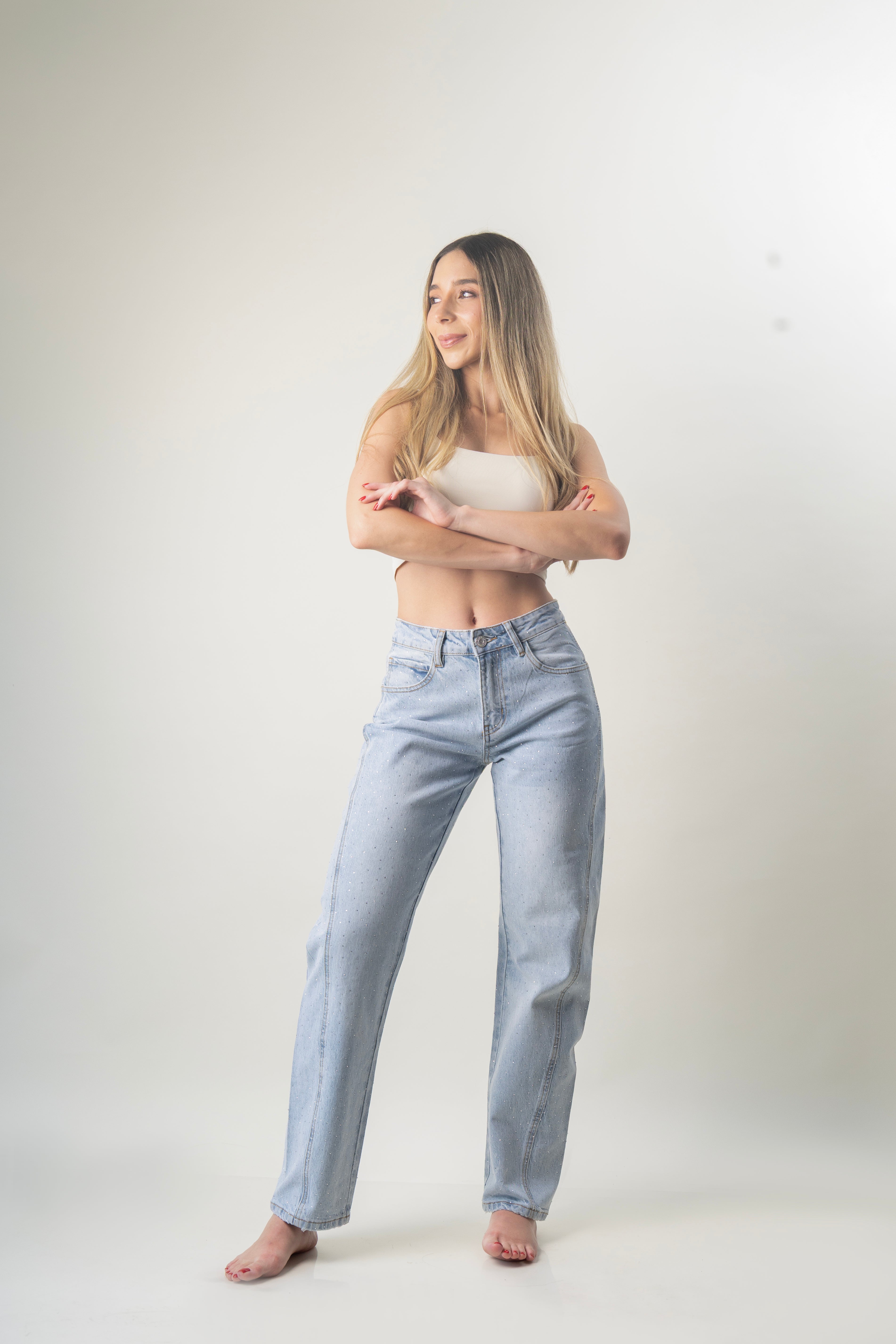 Barrel jeans azul claro con brillos dispersos en look completo.