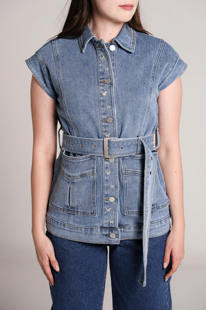 Detalle de chaleco de mezclilla azul para mujer con cinturón y bolsillos frontales.