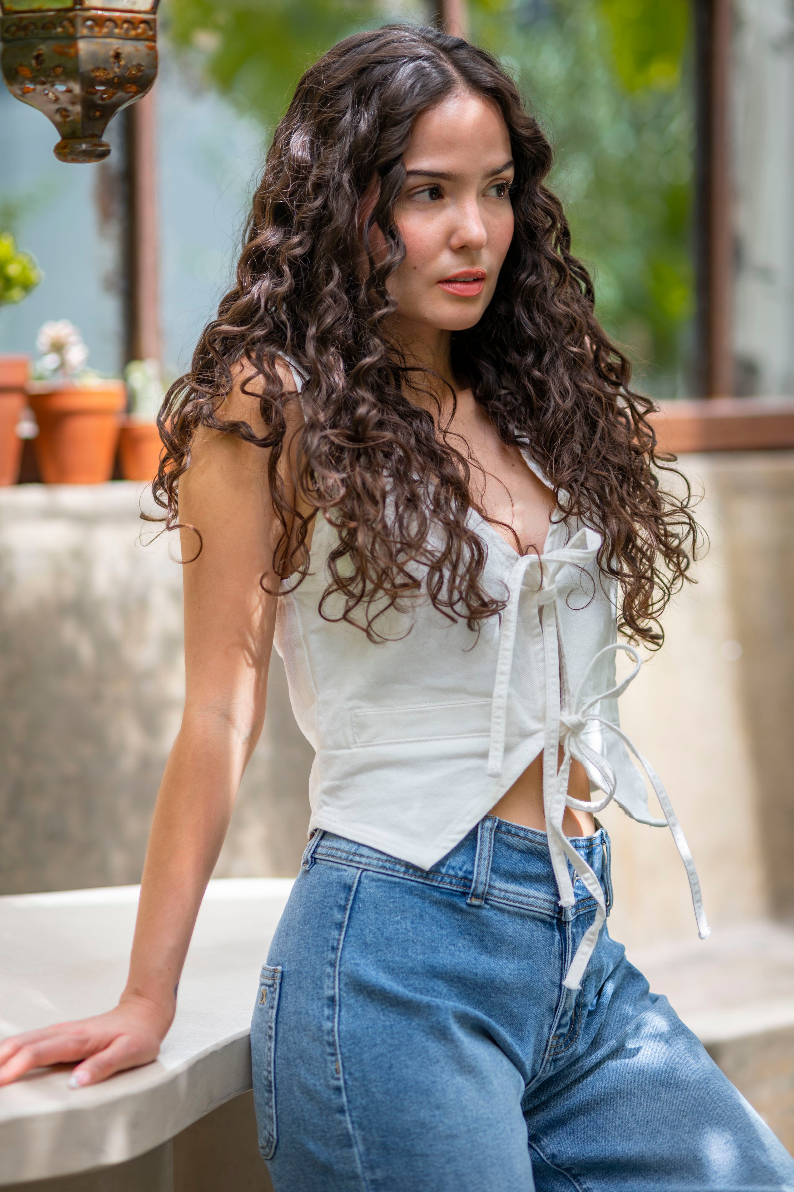 Chaleco mujer blanco, vista frontal completa con diseño entallado y combinación con jeans