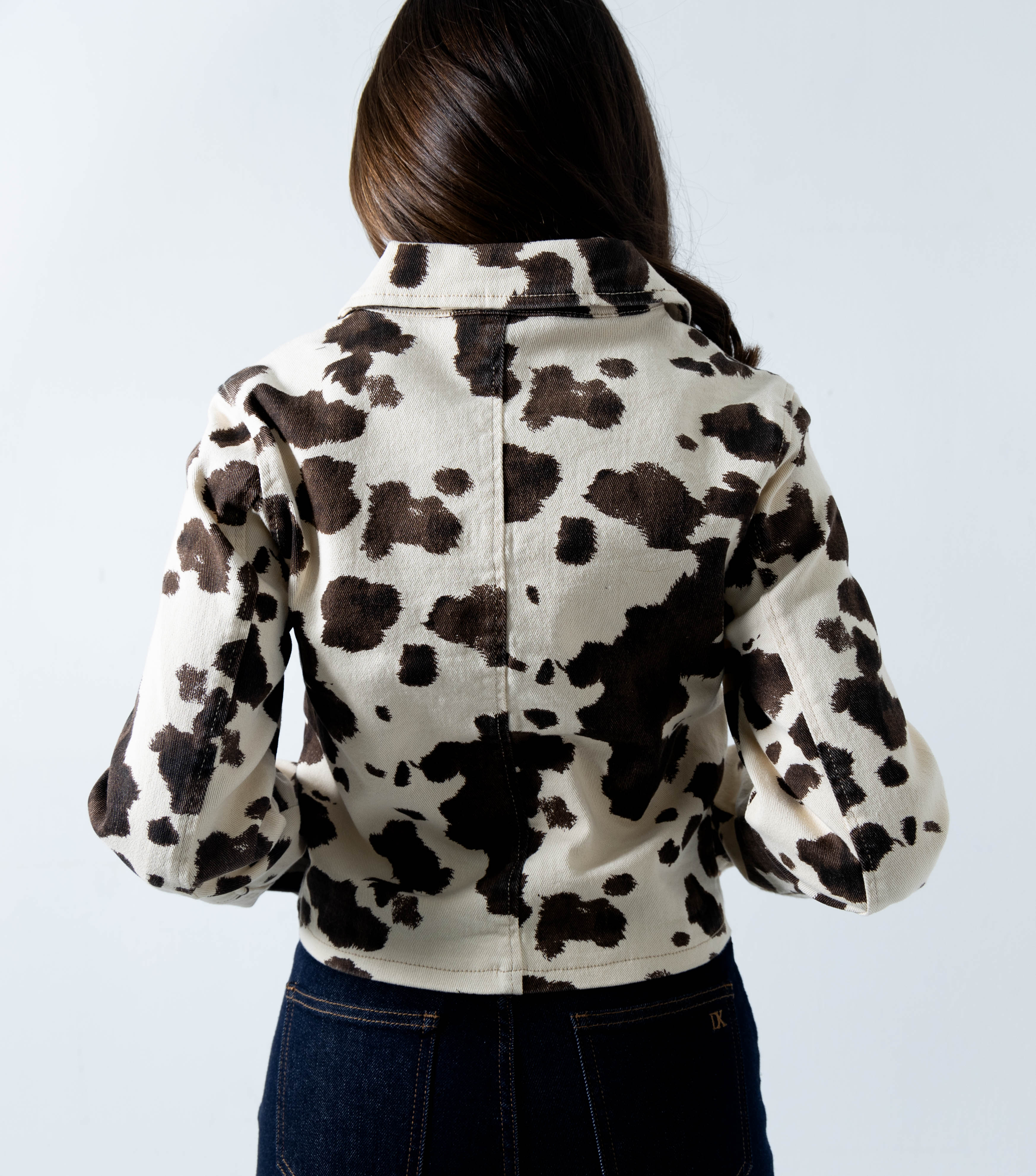 Vista trasera de chamarra de mezclilla estampada cow print para mujer