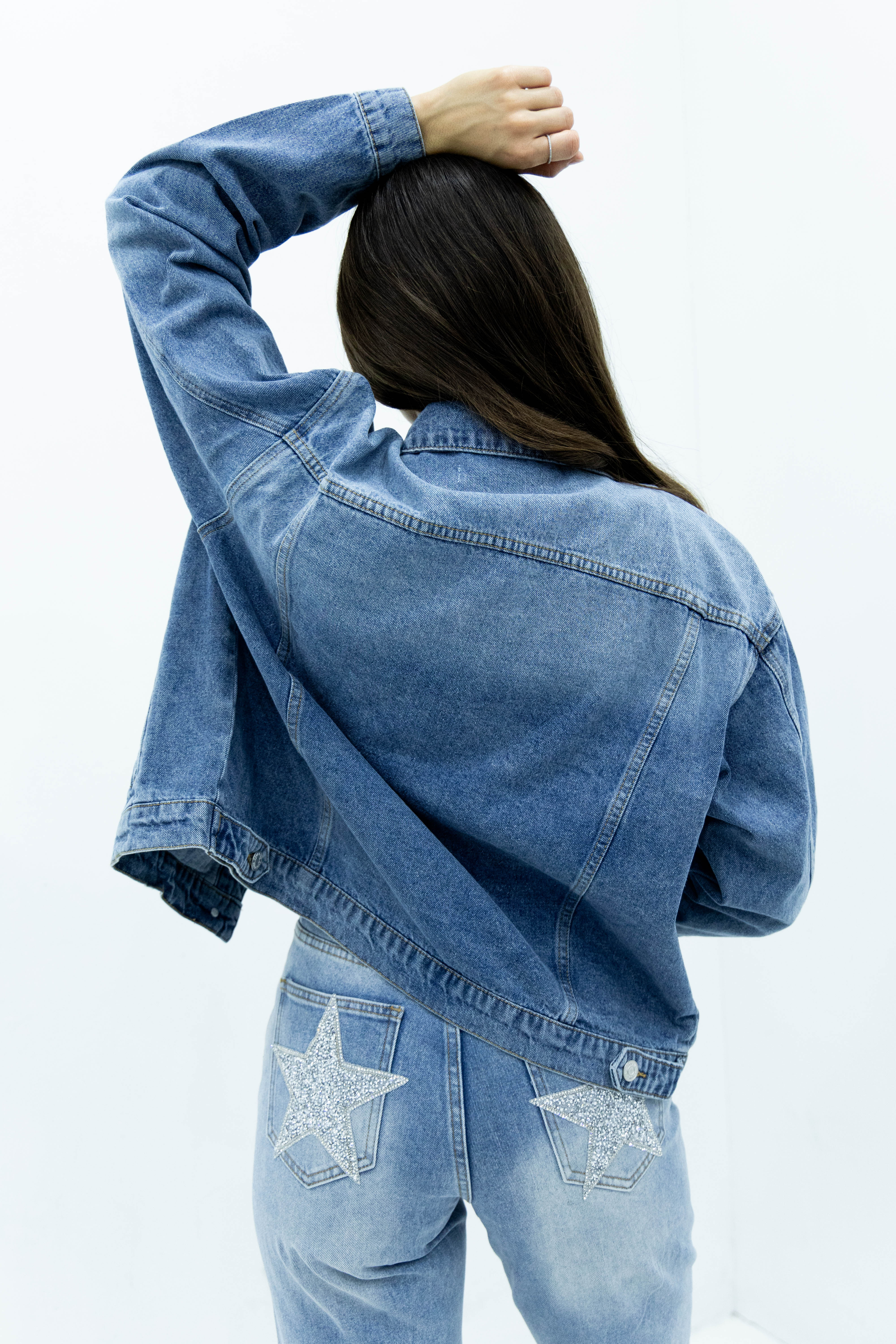 Vista trasera de chamarra de mezclilla azul para mujer con diseño relajado