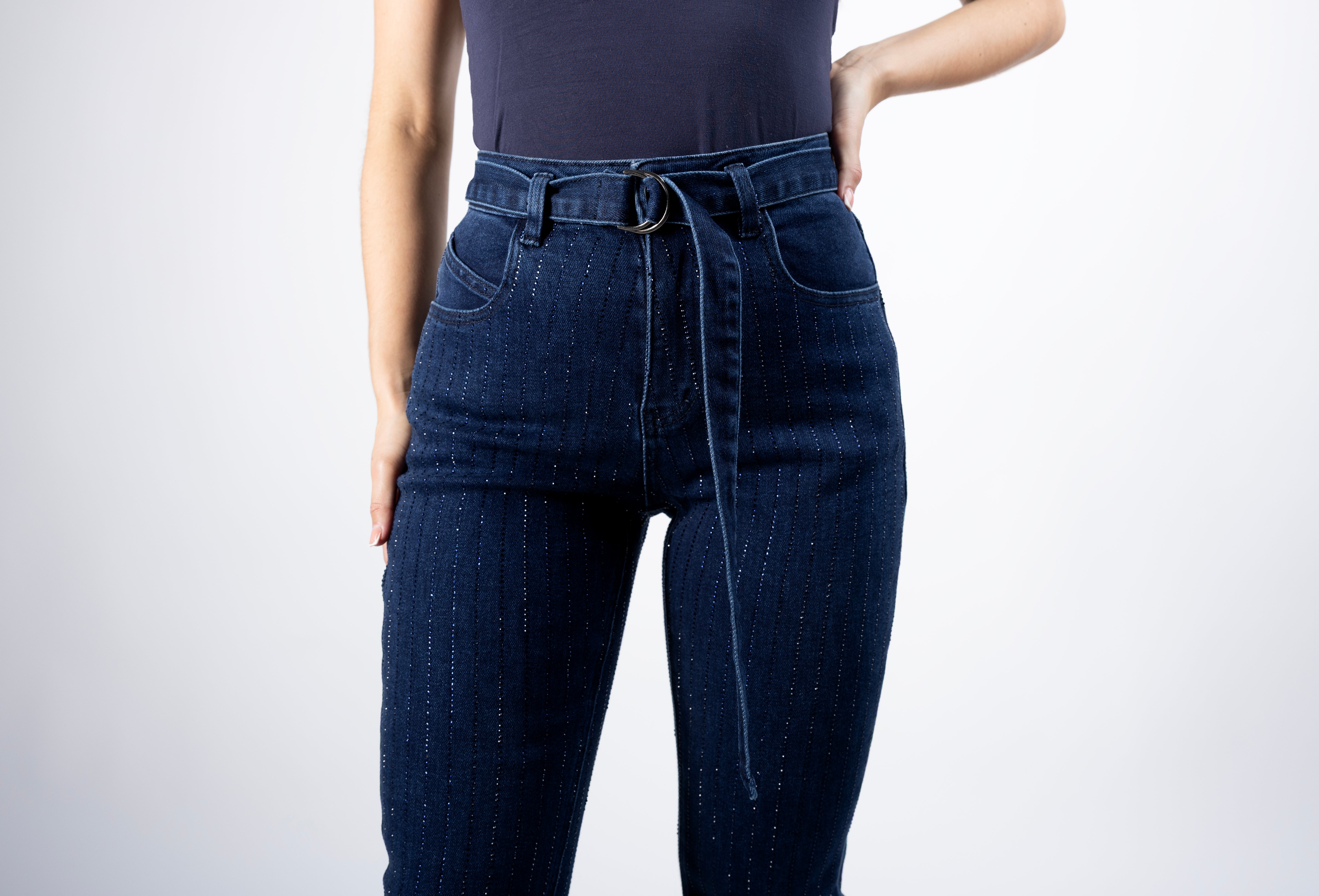 Detalle frontal de pantalon acampanado azul con brillos y cinturón
