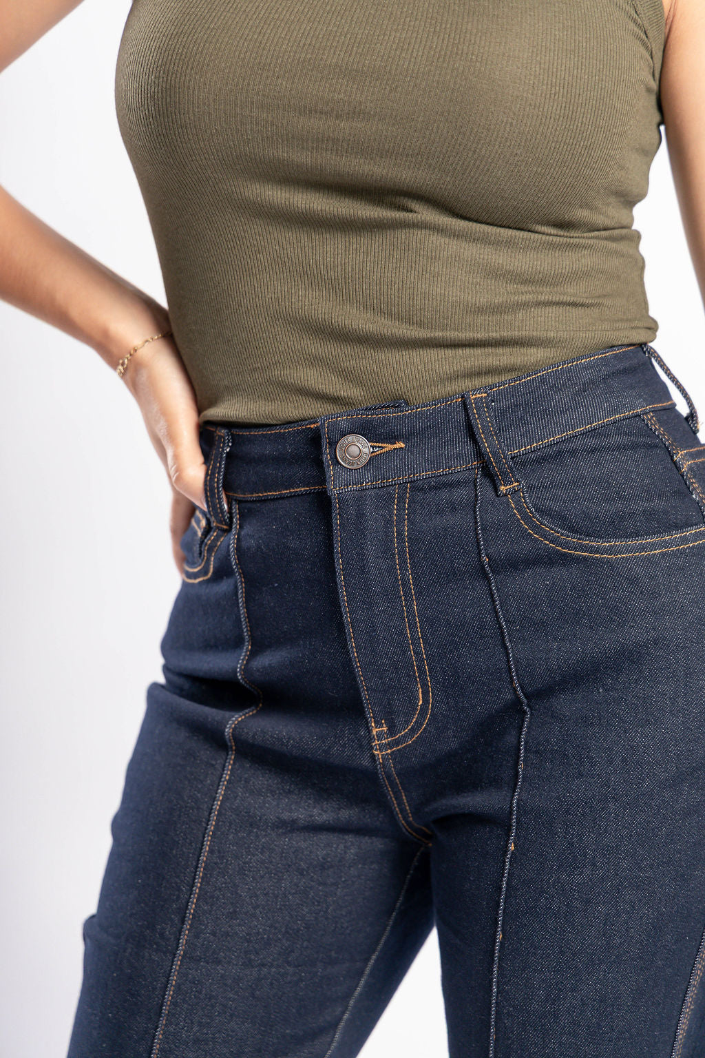 Detalle frontal de pantalon acampanado índigo con costuras contrastantes