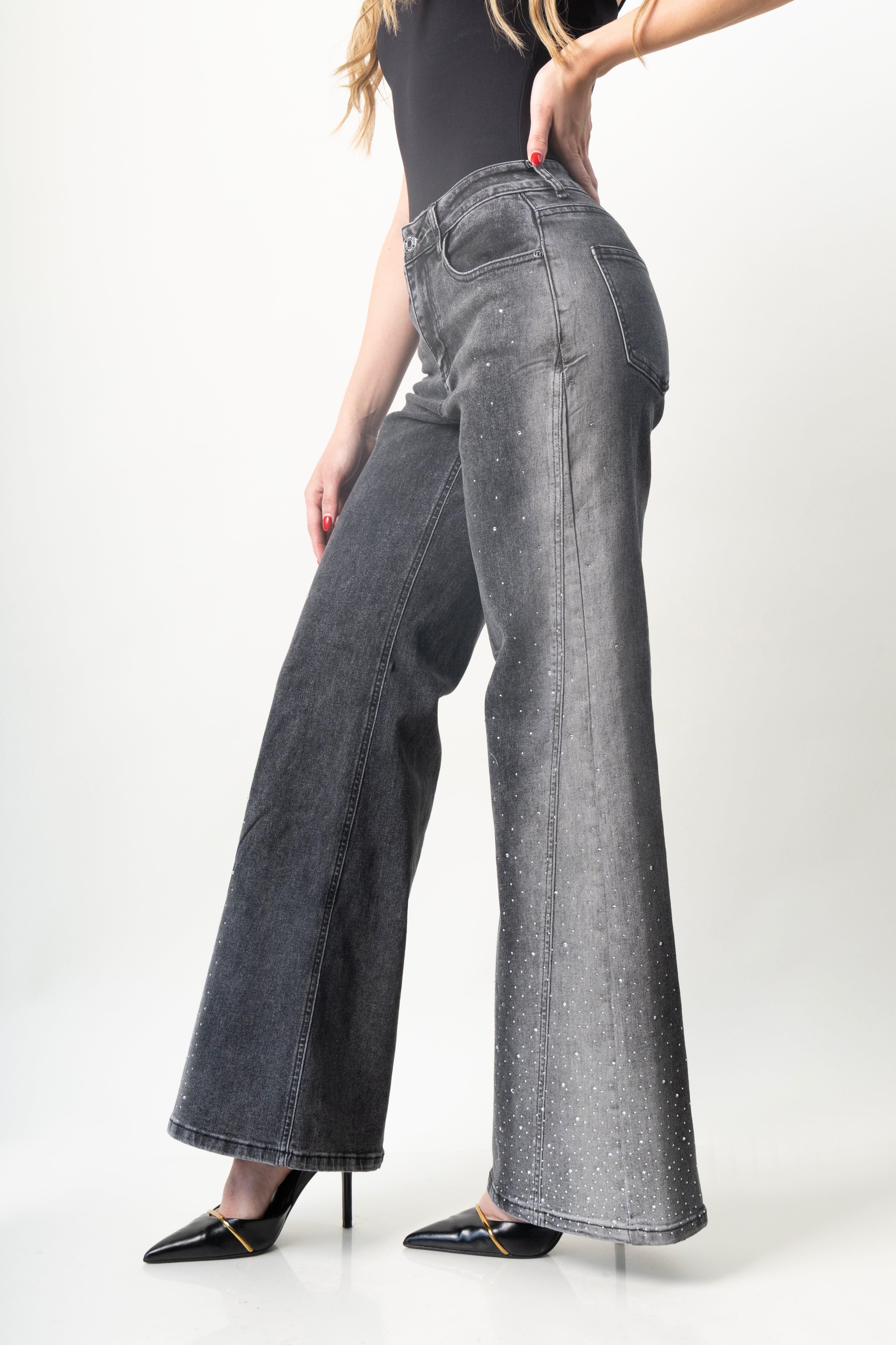 detalle lateral de pantalon acampanado gris con brillos y tiro alto