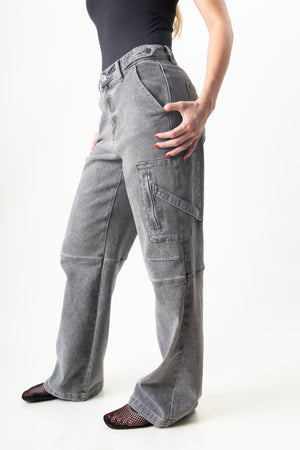 detalle lateral de pantalon cargo gris con bolsillo utilitario y cierre