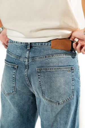Pantalon de hombre azul detalle trasero con etiqueta y bolsa