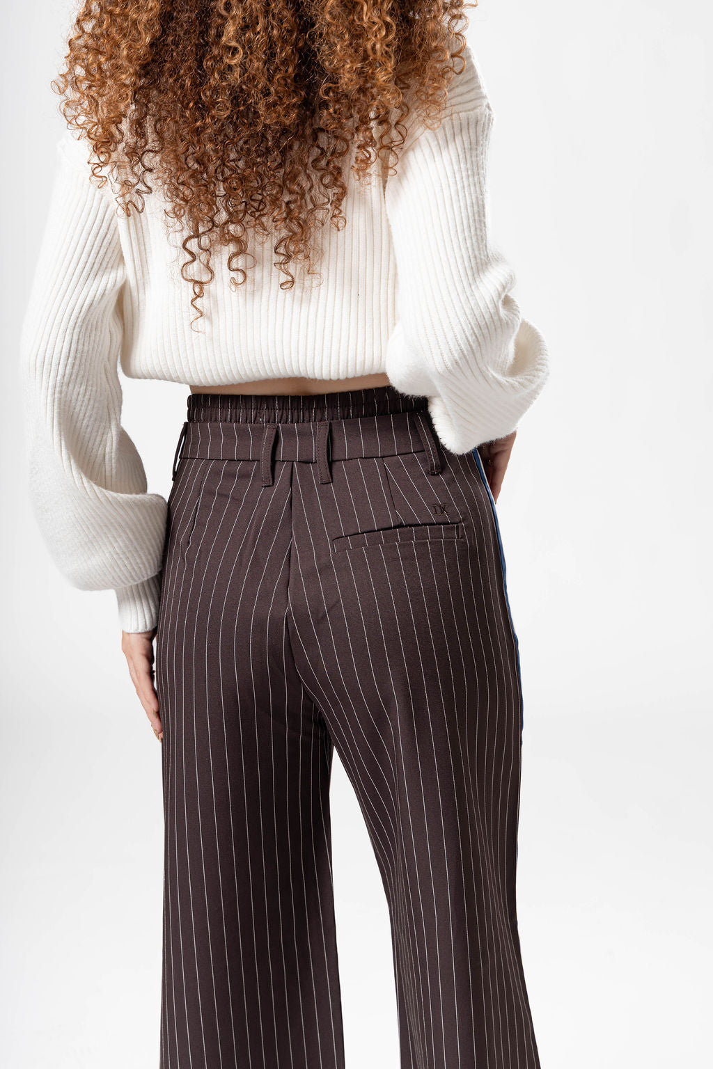 Vista trasera de pantalon de vestir chocolate para mujer con detalle lateral azul