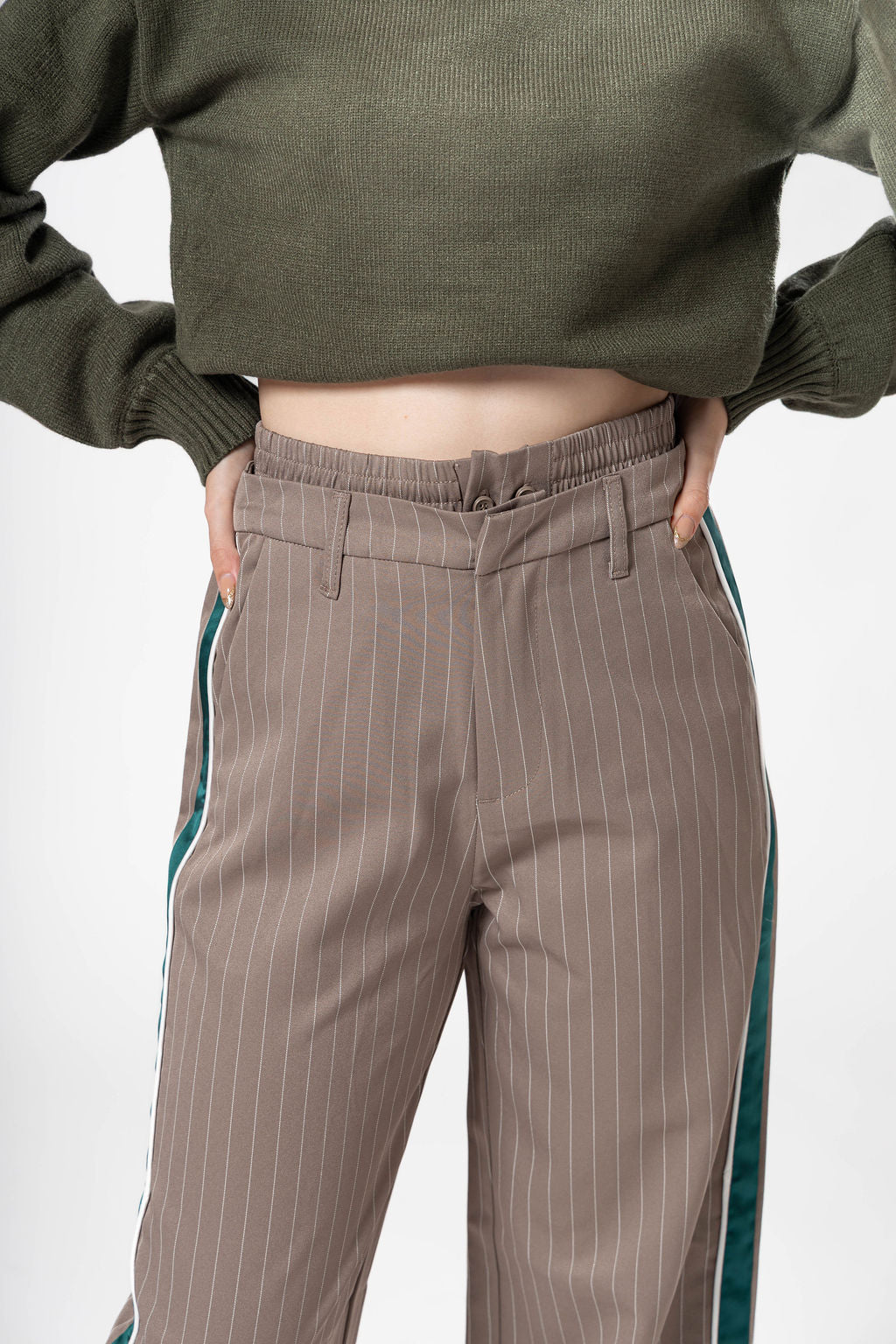 Detalle frontal de pantalon de vestir taupe con diseño de rayas verticales