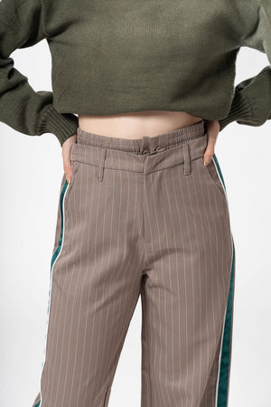 Detalle frontal de pantalon de vestir taupe con diseño de rayas verticales