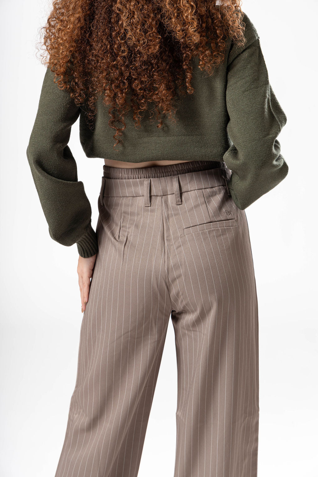 Vista trasera cercana de pantalon de vestir taupe con bolsas posteriores