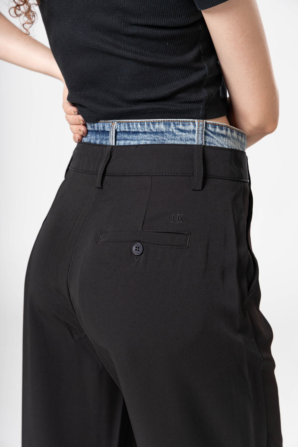Vista trasera de pantalon de vestir black para mujer con detalle denim y bolsillo posterior decorativo