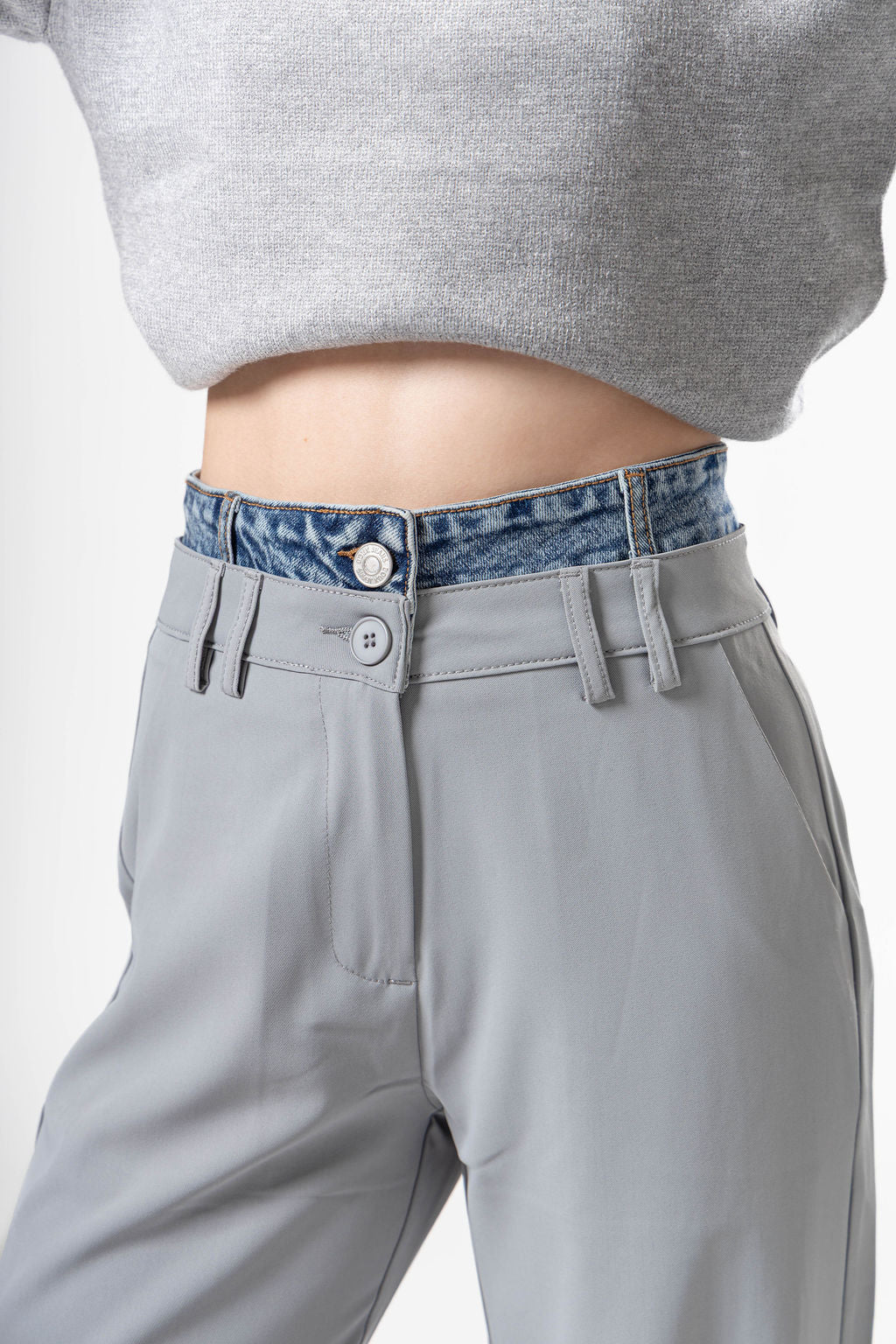 Detalle frontal de pantalon de vestir gray con pretina tipo mezclilla y diseño elegante