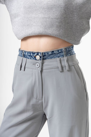 Detalle frontal de pantalon de vestir gray con pretina tipo mezclilla y diseño elegante