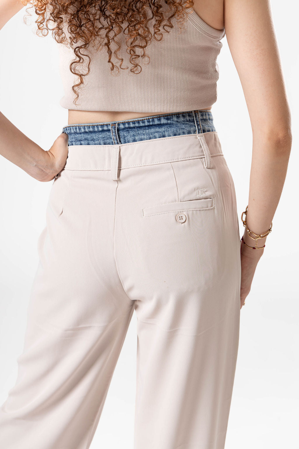 Vista trasera de pantalon de vestir ivory para mujer con detalle denim y bolsillo posterior decorativo