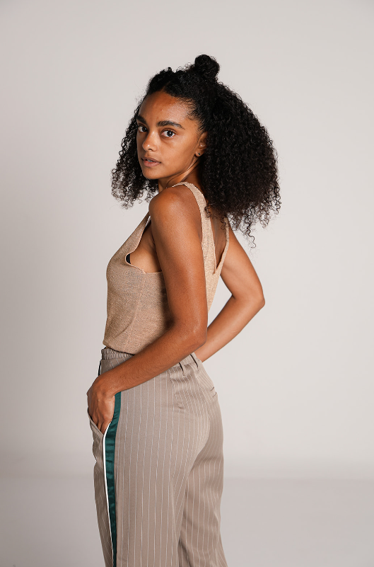 Detalle lateral del pantalon de vestir beige con rayas verticales y franjas verdes para mujer.
