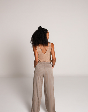 Vista trasera del pantalon de vestir beige de pierna amplia con rayas verticales y franjas laterales verdes.