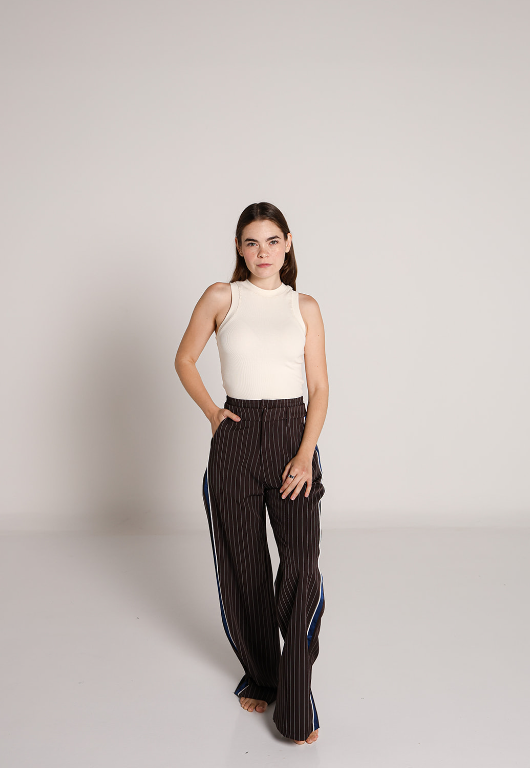 Mujer usando pantalon de vestir chocolate con rayas verticales y detalle lateral azul.