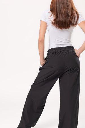 pantalon recto negro vista trasera con pretina elastica y caida amplia en modelo