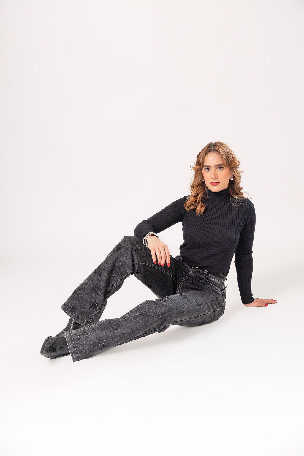 pantalon recto negro con brillos de estrellas outfit completo con modelo sentada