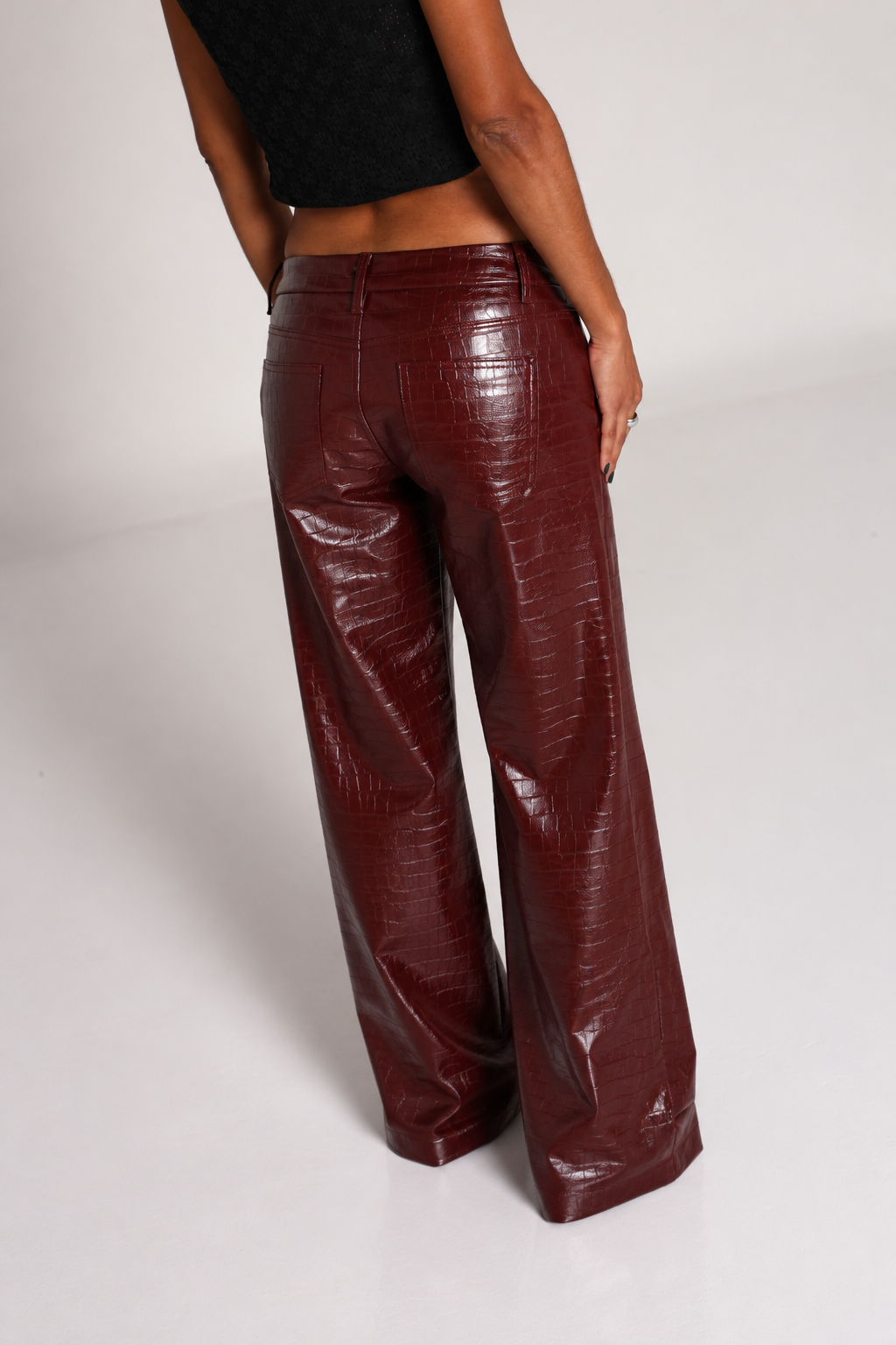 Pantalon straight burgundy con textura tipo cocodrilo y acabado brillante.