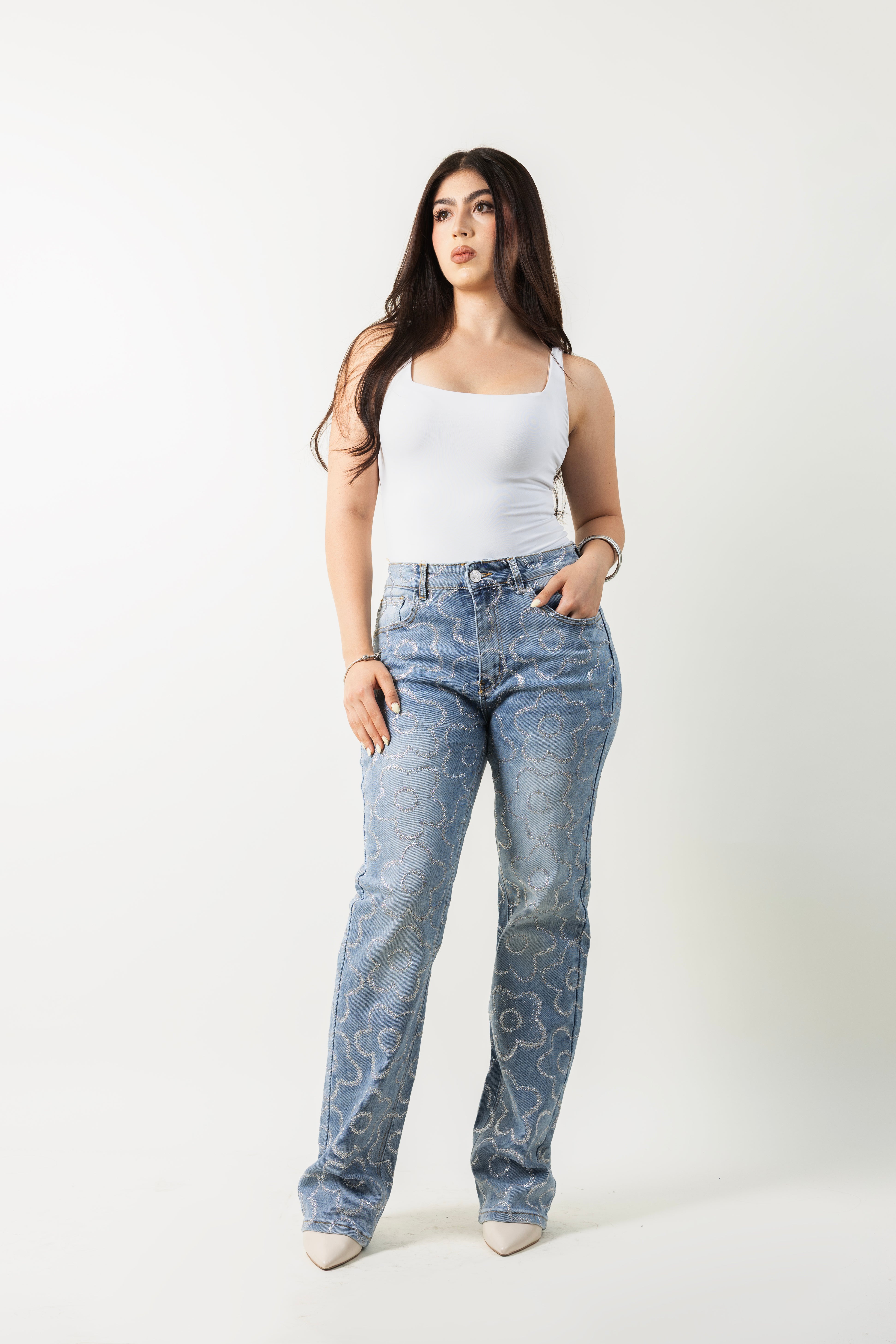 Pantalon straight de mezclilla azul con diseño floral de diamantina plateada, vista frontal.