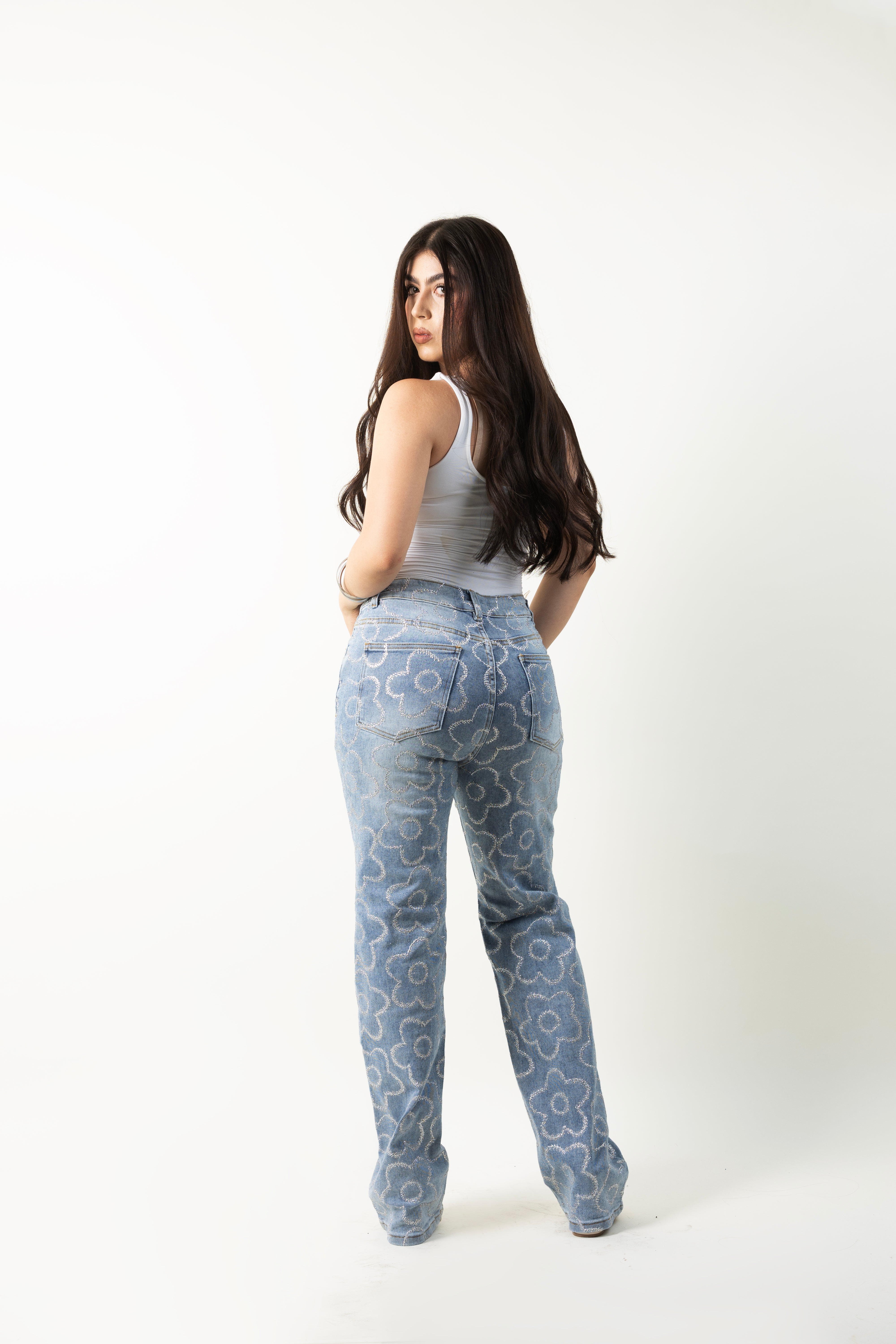 Pantalon straight azul para mujer con flores de diamantina plateada, vista posterior.