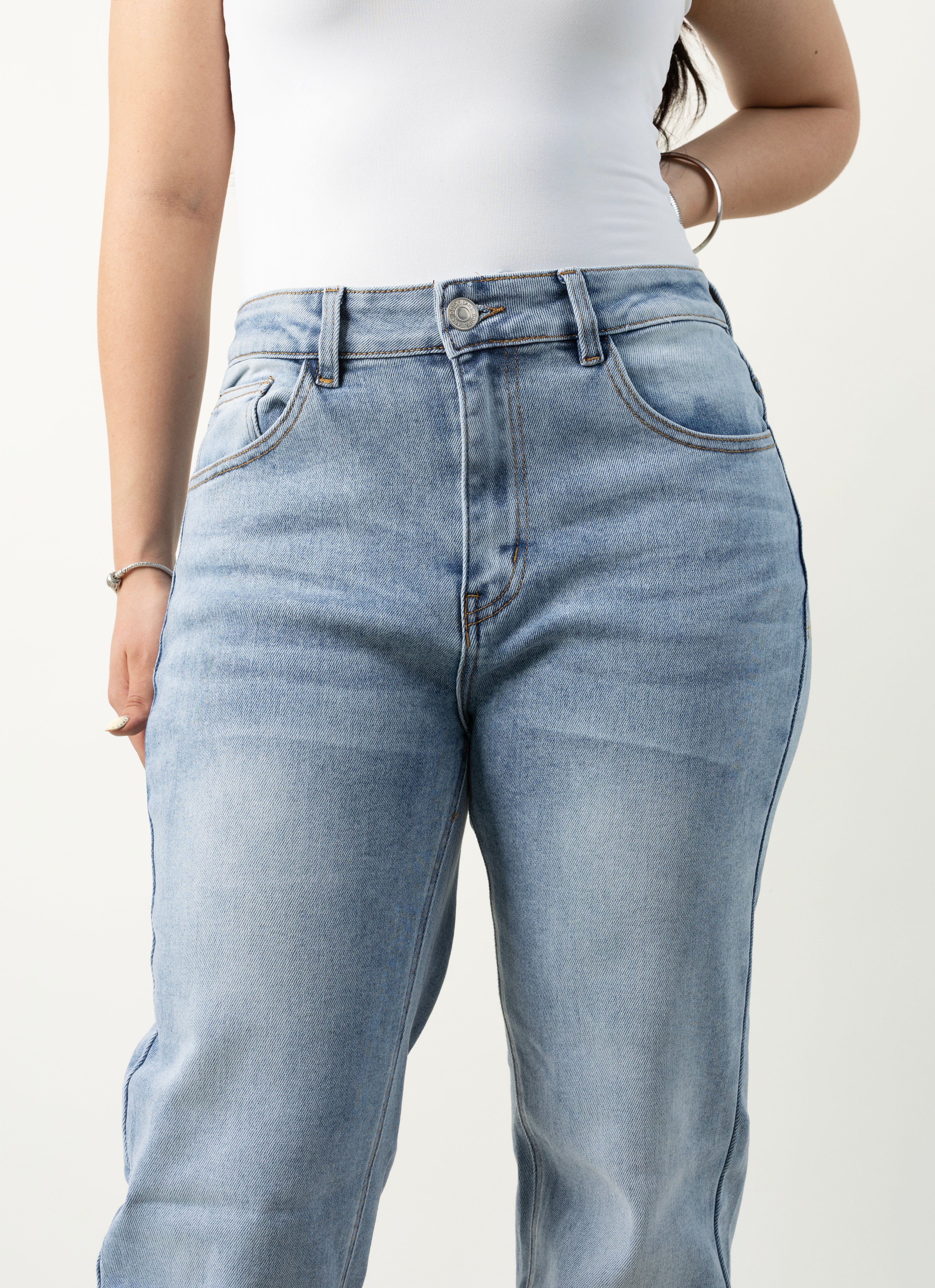 Detalle frontal de pantalon straight azul claro con bolsillos delanteros.
