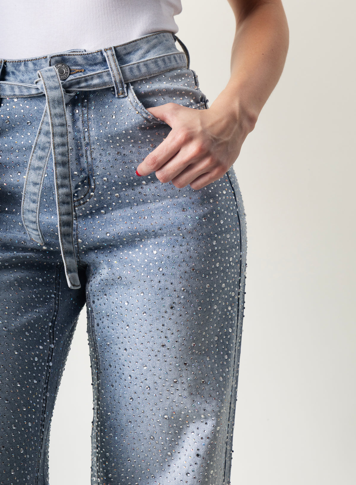 Detalle de brillos decorativos en pantalon wide leg de mezclilla azul.